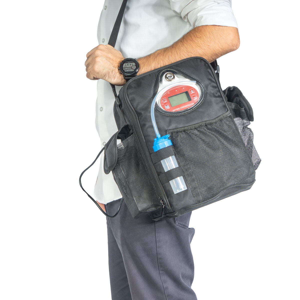Person wearing a black portable oxygen concentrator bag with a red display panel and a blue-capped canister attached to the side strap.