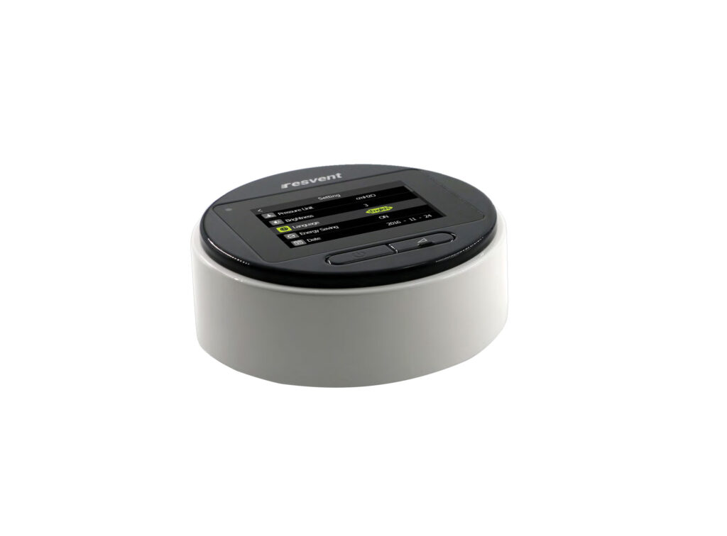 Close-up of a round medical device with a color touchscreen displaying settings like Pressure Unit, Brightness, Language, and Energy Saving