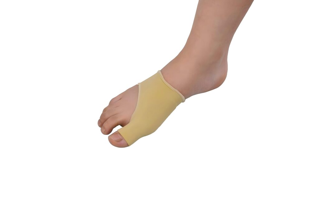 Foot wearing a beige silicone toe protector covering the base of the big toe and adjacent toe