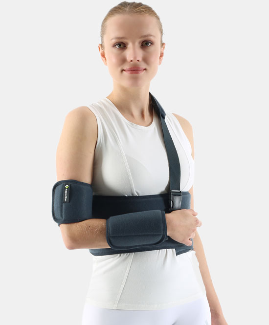 Woman wearing a blue arm and elbow immobilizer with forearm and upper-arm supports secured by straps on a white top.