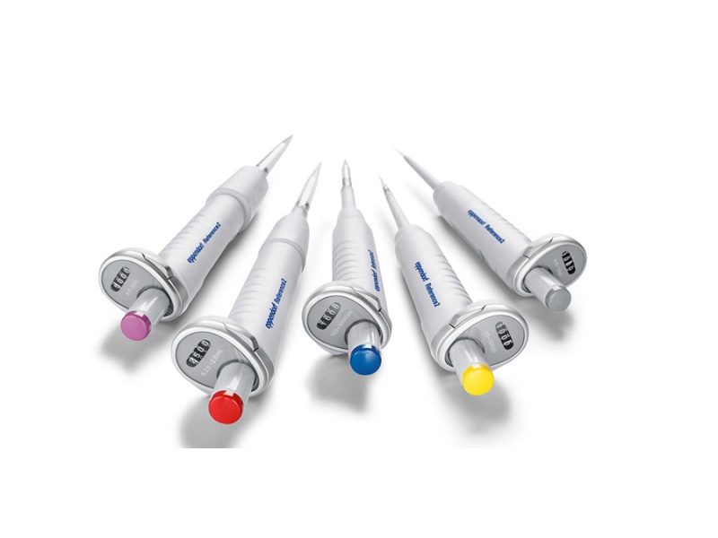 Five white dental dispensing syringes with color-coded caps on a white background as a group arrangement.